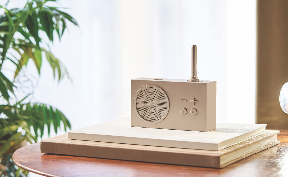 Radioodtwarzacz LEXON Tykho 3 złoty, radio, muzyka, funkcjonalność, Technologia,  Radio Lexon Tykho 3 stoi na jasnych książkach, roślina w tle, minimalistyczny wystrój.