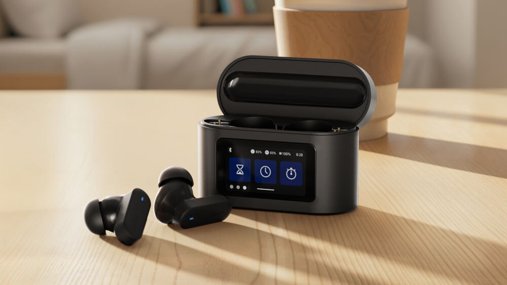 Słuchawki dokanałowe PHILIPS TAT6000BK/00 wielozadaniowa obudowa wysoka jakość dźwięku, etui z funkcją ładowania oraz słuchawki dokanałowe stojące na stole w pomieszczeniu