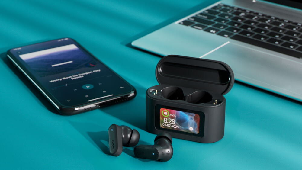 Słuchawki dokanałowe PHILIPS TAT6000BK/00 Bluetooth 5.4 multipoint stabilne połączenie, etui z słuchawkami dokanałowymi leżące na stole obok smartfona oraz laptopa