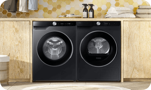 Suszarka AI 9kg DV9XDG6845LBU4 Pralka i suszarka umieszczone obok siebie w nowoczesnej łazience z drewnianymi akcentami.