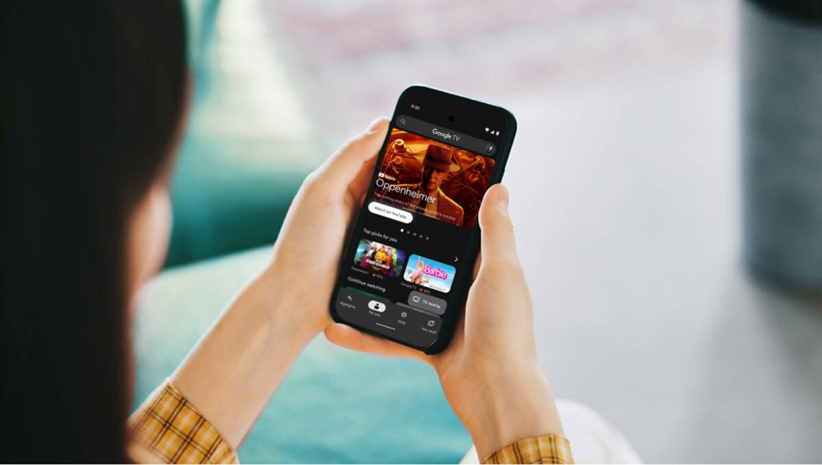 SHARP 85HP5765E Aplikacja Google TV sterowanie telewizorem bezpośrednio z telefonu wyszukiwanie filmów i programów przyspiesza wprowadzanie haseł klawiaturze - telefon w ręku kobiety z aplikacją google tv