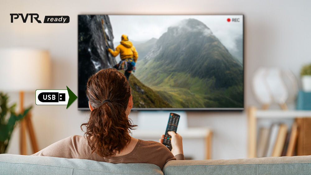 Telewizor JVC LT-65VG7500 PVR nagrywanie USB programy telewizja planowanie, osoba siedząca na kanapie z pilotem w ręku oglądające film