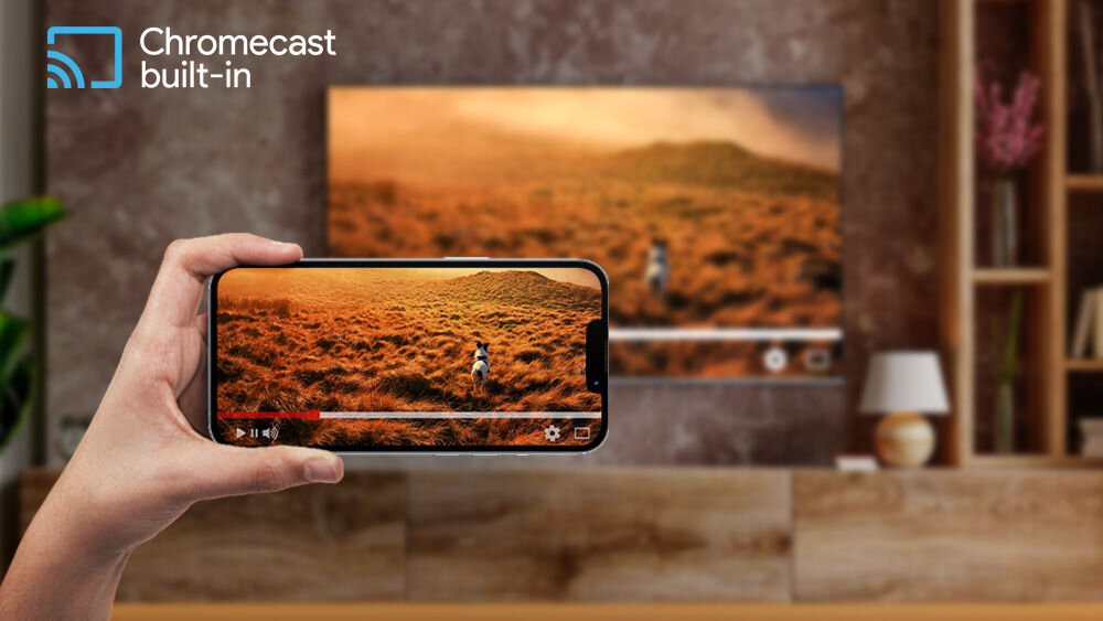 Telewizor JVC LT-43VG7500 Chromecast przesyłanie zdjęć filmów muzyki telefon laptop, telewizor zawieszony na ścianie, osoba trzymająca smartfon w ręku