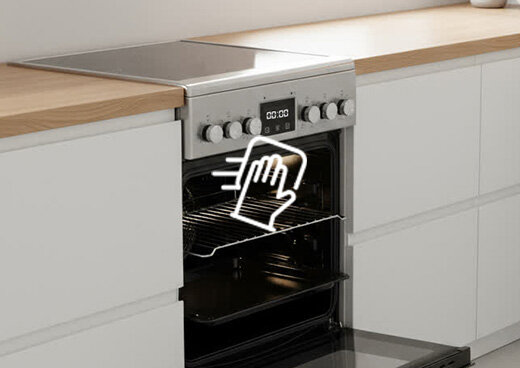 Otwarty piekarnik kuchenki elektrycznej z płytą ceramiczną MPM-55-KEC-40. Na piekarniku symbol ręki i ściereczki.