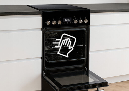 Otwarty piekarnik kuchenki elektrycznej z płytą ceramiczną MPM-55-KEC-41. Na piekarniku symbol ręki i ściereczki.