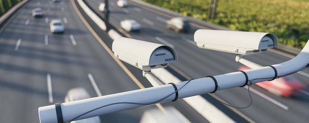 MIO MiVue 956W pokazując dystans i czas do zbliżającego się fotoradaru informując o obowiązującym ograniczeniu prędkości oblicza średnią prędkość na odcinku Francji, Niemiec, Szwajcarii i Turcji - zdjęcie przedstawiające kamery nad autostradą