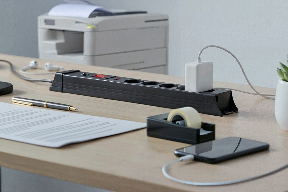 Listwa HAWK HWPS502BK (1.5 m) Czarny, gniazda, uziemienie, porządek, biuro, w tle dziecko i logotyp ochrony dziecka, na pierwszym planie część listwy