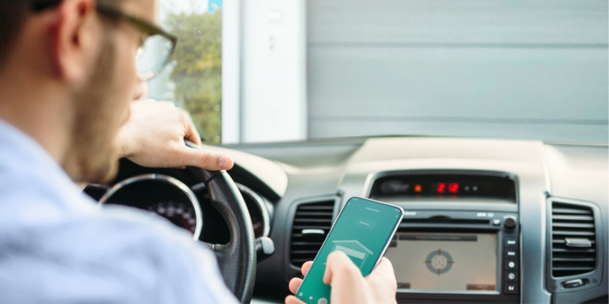 Sterownik bramy garażowej HAMA Smart WiFi, Alexa, Google, Siri, sceny, Kierowca w samochodzie korzystający z aplikacji smart home do sterowania bramą garażową.