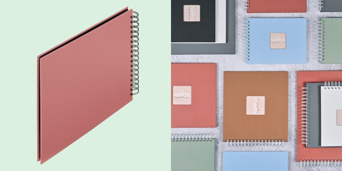 Album HAMA Fine Art Czarne kartki Ceglany (50 stron) Album fotograficzny na spirali zaprezentowany na tle kolorowej kolekcji albumów materiałowych.