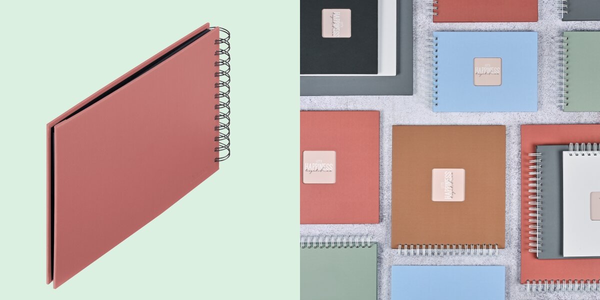 Album HAMA Fine Art Czarne kartki Ceglany (50 stron) Album fotograficzny na spirali zaprezentowany na tle kolorowej kolekcji albumów materiałowych.