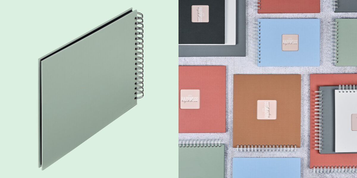 Album HAMA Fine Art Czarne kartki Szarozielony (50 stron) Album fotograficzny na spirali zaprezentowany na tle kolorowej kolekcji albumów materiałowych.