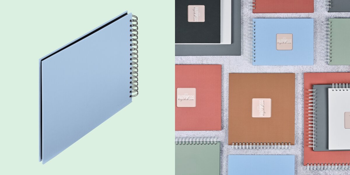 Album HAMA Fine Art Czarne kartki Błękitny (50 stron) Album fotograficzny na spirali zaprezentowany na tle kolorowej kolekcji albumów materiałowych.