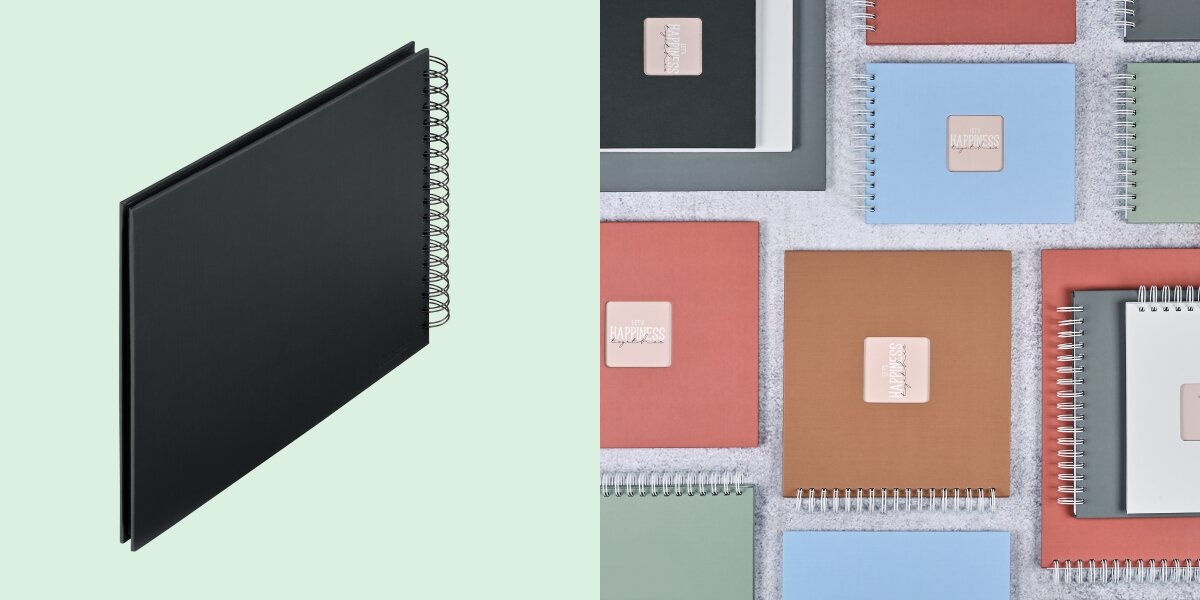 Album HAMA Fine Art 9834 Czarne kartki Czarny (50 stron) Album fotograficzny na spirali zaprezentowany na tle kolorowej kolekcji albumów materiałowych.