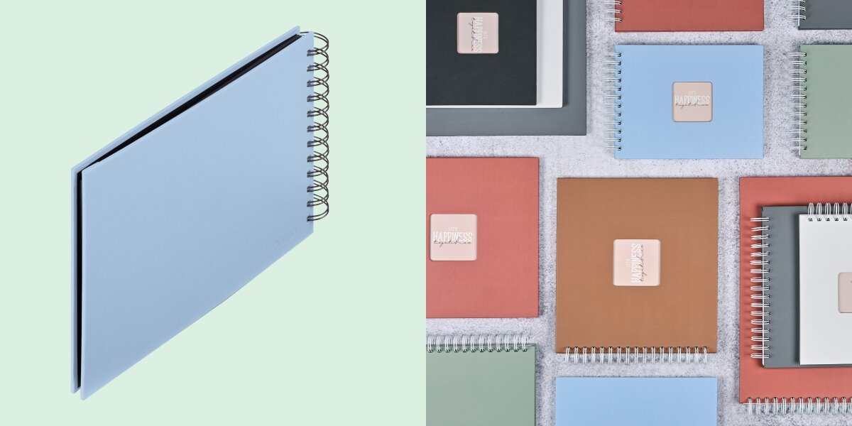 Album HAMA Fine Art Czarne kartki Błękitny (50 stron) Album fotograficzny na spirali zaprezentowany na tle kolorowej kolekcji albumów materiałowych.