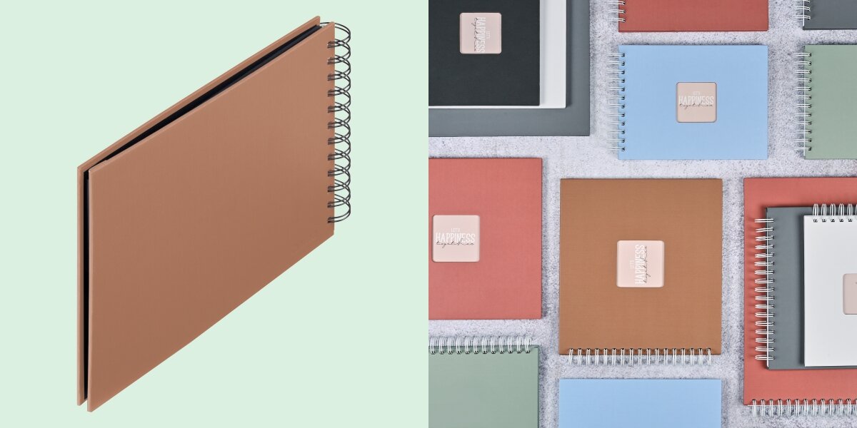 Album HAMA Fine Art Czarne kartki Ceglany (50 stron) Album fotograficzny na spirali zaprezentowany na tle kolorowej kolekcji albumów materiałowych.