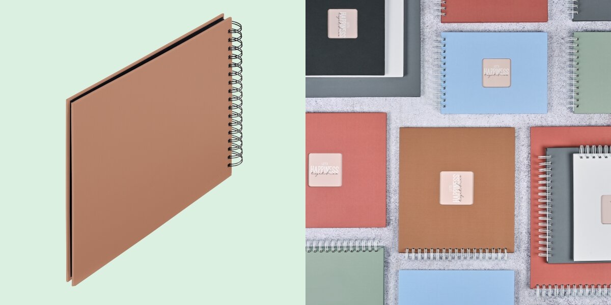 Album HAMA Fine Art Czarne kartki Brązowy (50 stron) Album fotograficzny na spirali zaprezentowany na tle kolorowej kolekcji albumów materiałowych.