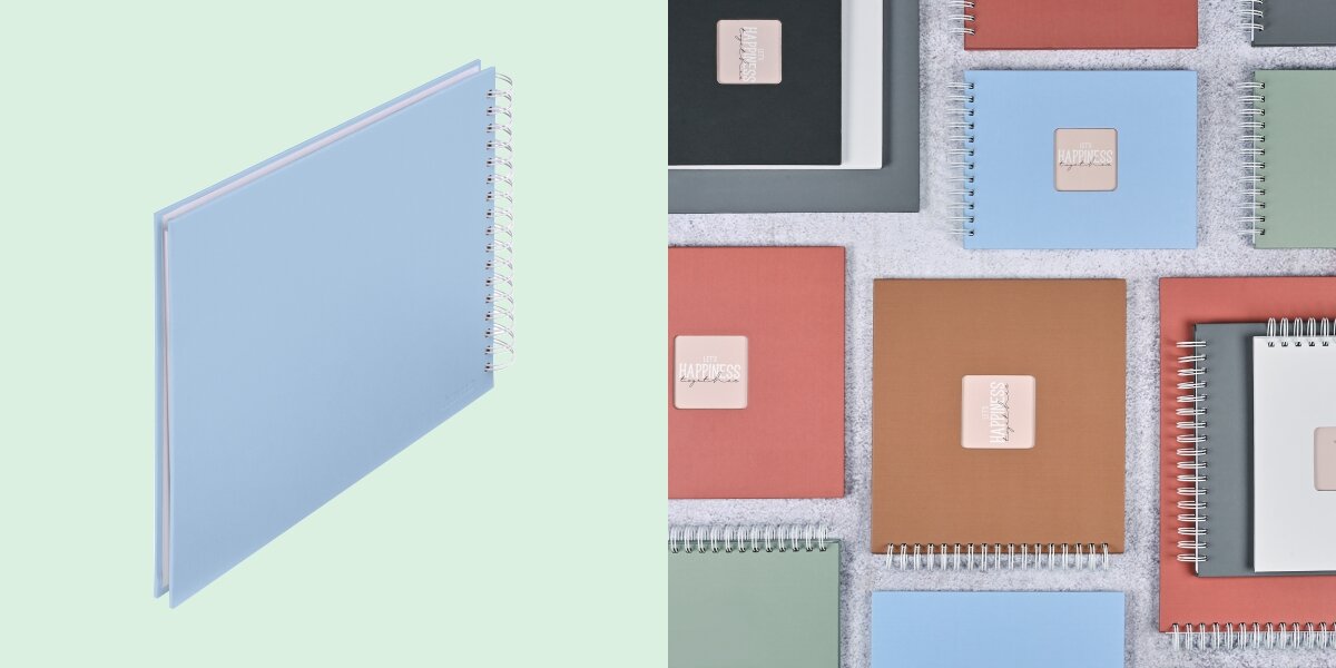 Album HAMA Fine Art Białe kartki Błękitny (50 stron) Album fotograficzny na spirali zaprezentowany na tle kolorowej kolekcji albumów materiałowych.