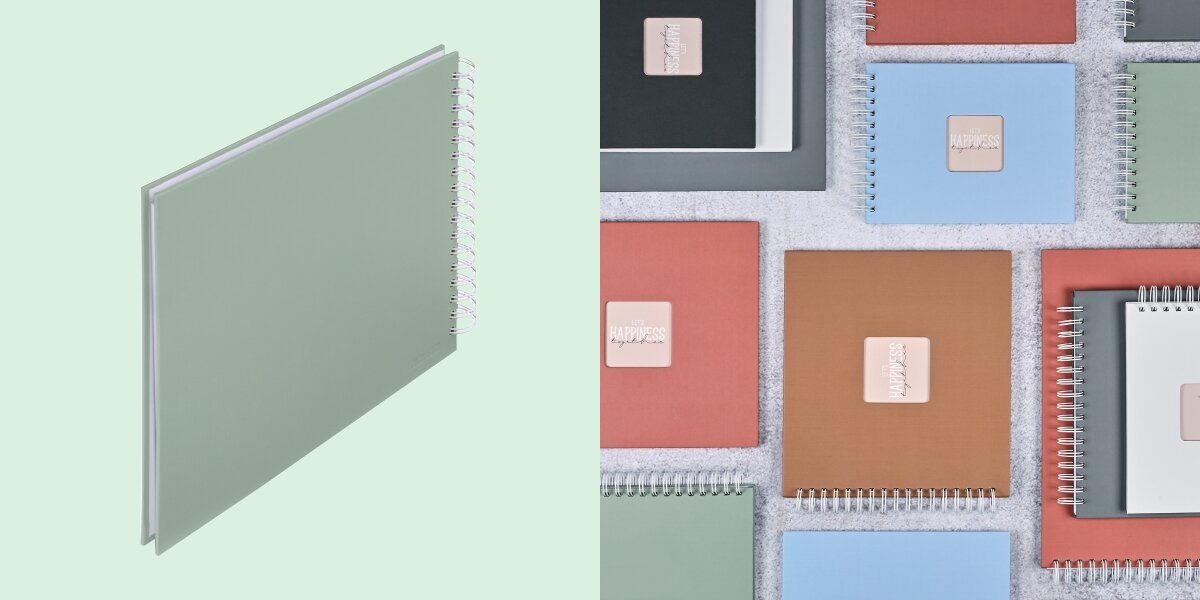 Album HAMA Fine Art 9867 Białe kartki Szarozielony (50 stron) Album fotograficzny na spirali zaprezentowany na tle kolorowej kolekcji albumów materiałowych.