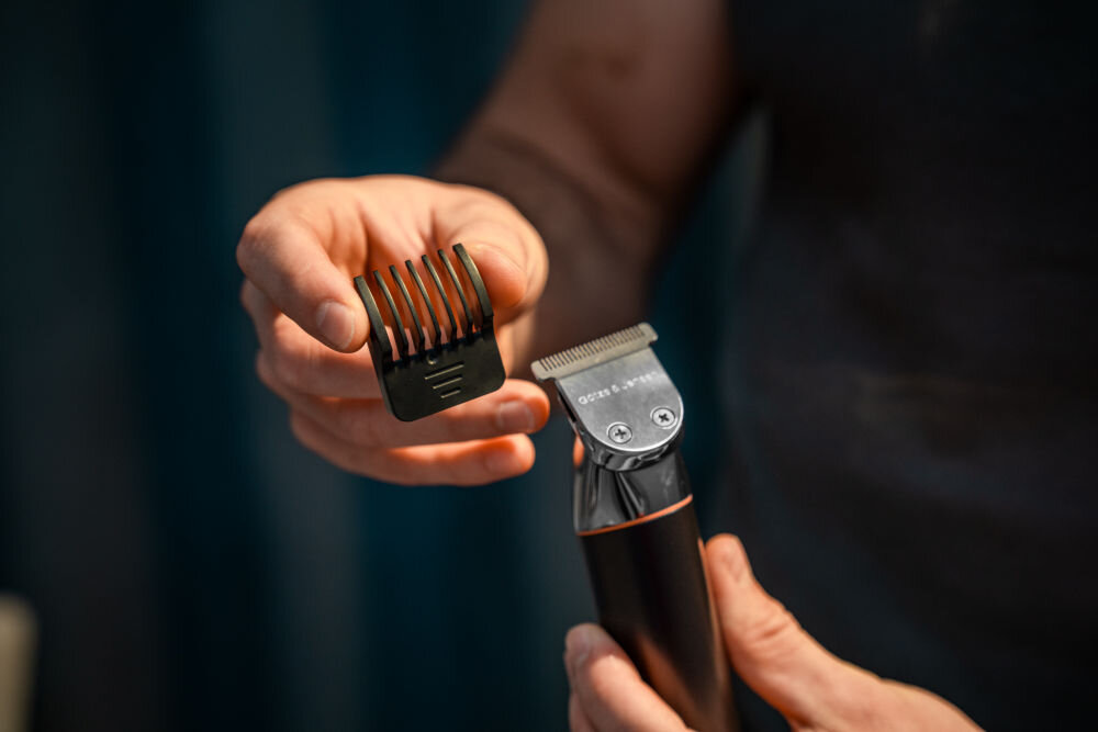 Trymer GÖTZE & JENSEN TR910 zbliżenie na szeroką nasadkę trymera i zdjętą z niej nakładkę grzebieniową ostrza pokryte tytanem odporność na korozję hipoalergiczność