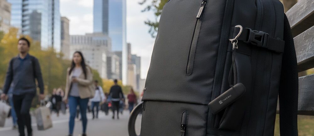 Czytnik kart pamięci NATEC Scarab C USB 3.2 Czarny Czytnik kart w kolorze czarnym przymocowany do plecaka w miejskim otoczeniu z przechadzającymi się ludźmi wymiary mieści się w małej kieszeni brelok