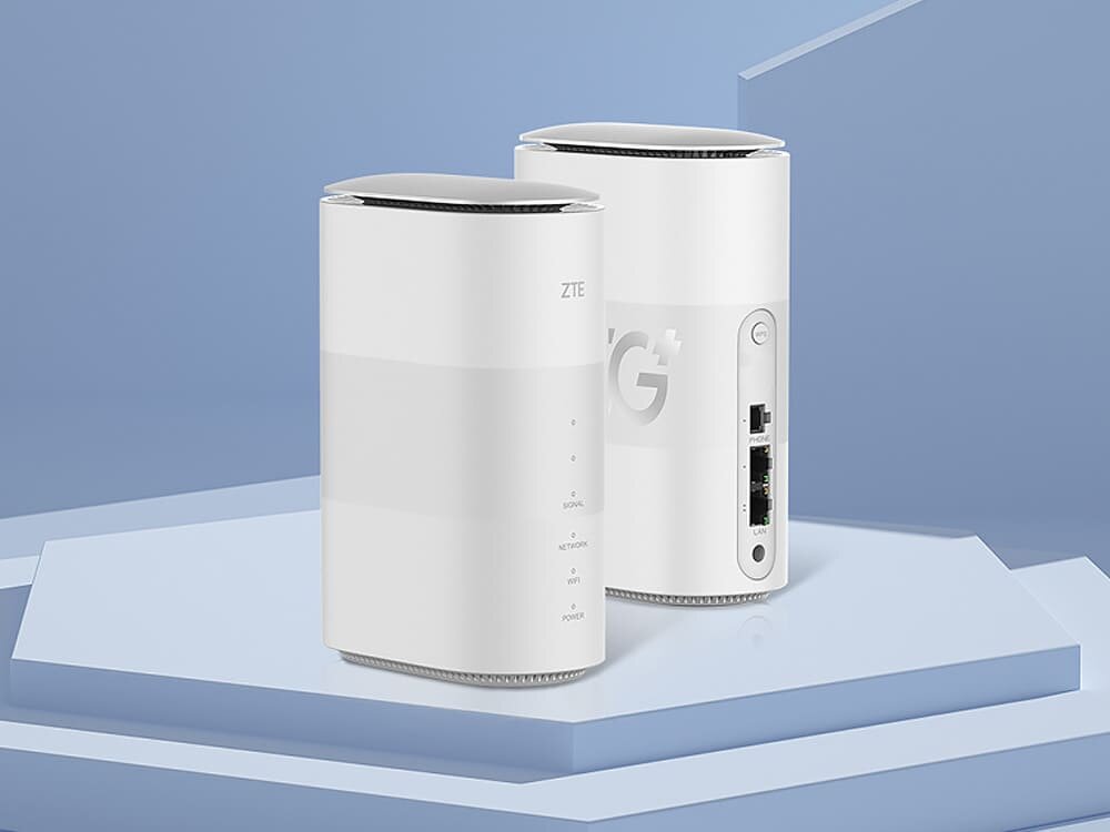 Router ZTE MC888B Dwa białe routery ZTE 5G MC888 ustawione na geometrycznej podstawie, jeden pokazuje przedni panel z diodami, a drugi tylny z portami LAN i telefonicznym. opis