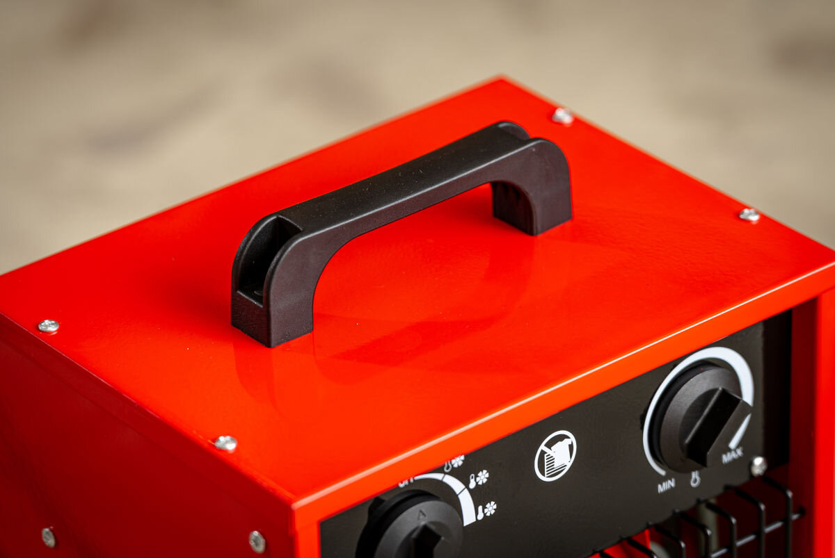 Nagrzewnica elektryczna DEDRA DED9921, remont, warsztat, osuszanie, ciągłość, Czarna rączka transportowa na górze nagrzewnicy DEDRA DED9921, zbliżenie detalu.