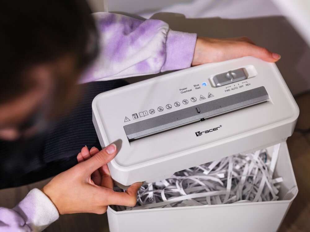 Niszczarka TRACER Razor 3 10 L, P-2, Paski, Automatyczny Start/Stop, Funkcja cofania Biały prezentacja niszczarki od góry osoba trzymająca jej pokrywę w środku widać pocięte dokumenty organizacja pracy poufność danych biuro dom komfort bezpieczeństwo