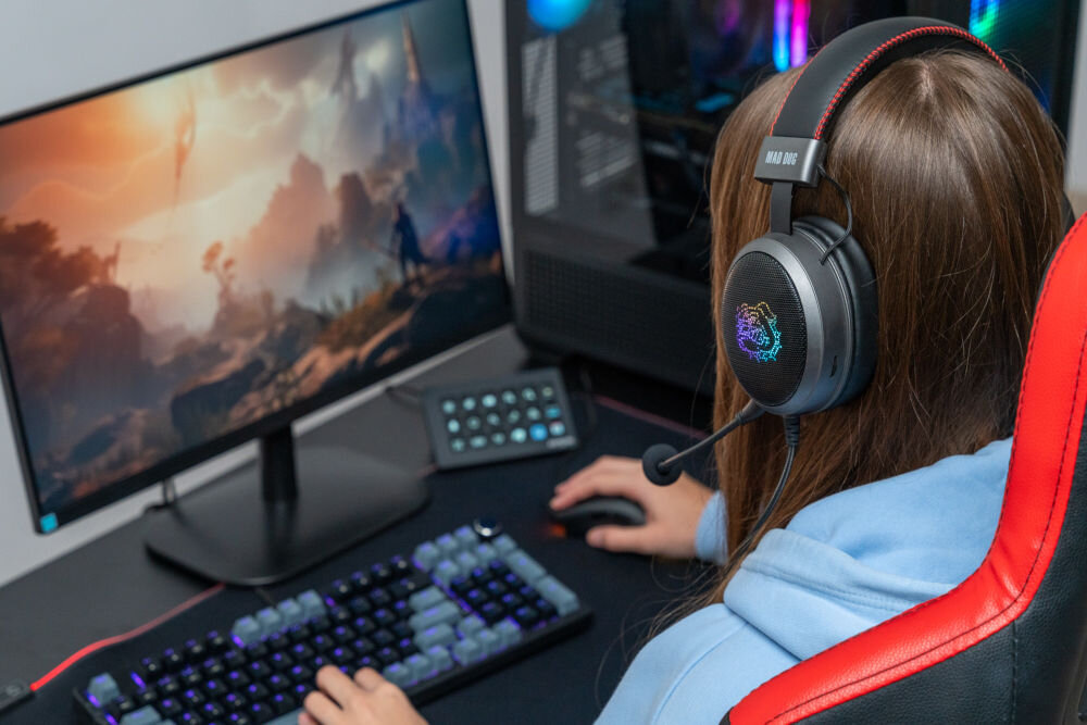 Słuchawki MAD DOG GH600K złożone przez osobę siedzącą przed komputerem stacjonarnym dźwięk przestrzenny 7.1