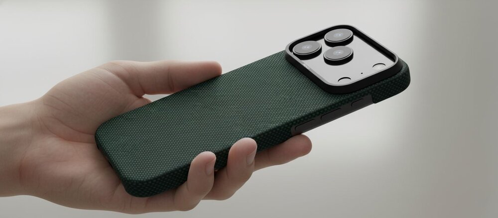 iPhone 17 Pro w zielonym etui YAXO z włókna aramidowego trzymany w jednej dłoni, widoczny smukły profil telefonu i prostokątna wyspa aparatów.