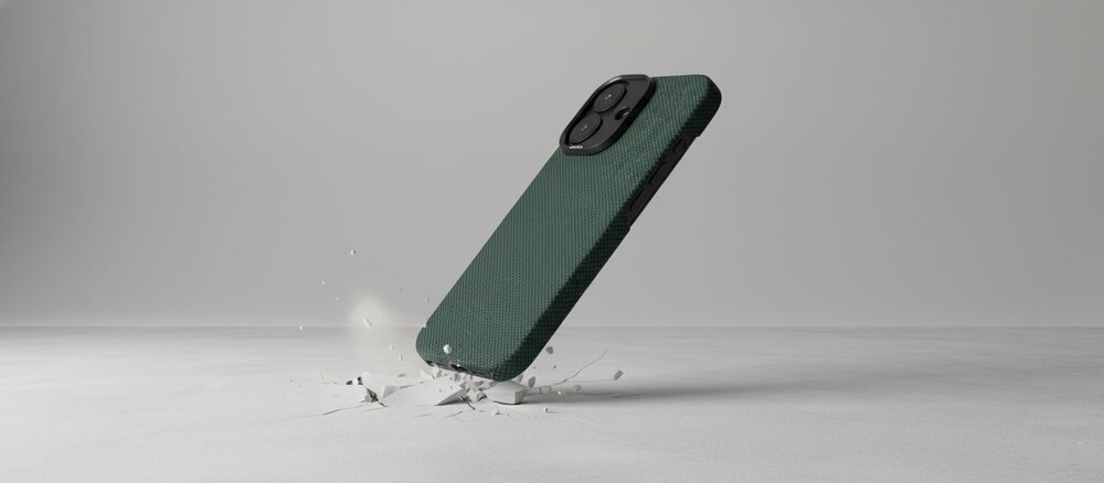 Ciemnozielone etui do iPhone 17 uderza o jasną podłogę, rozbijając ją na drobne odłamki, co symbolizuje ochronę telefonu przy upadku.