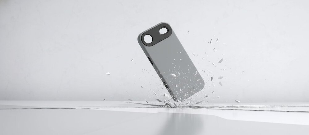 Szare etui do iPhone Air uderza o podłoże, rozbijając białą powierzchnię na odłamki, co symbolizuje ochronę telefonu przed upadkiem.