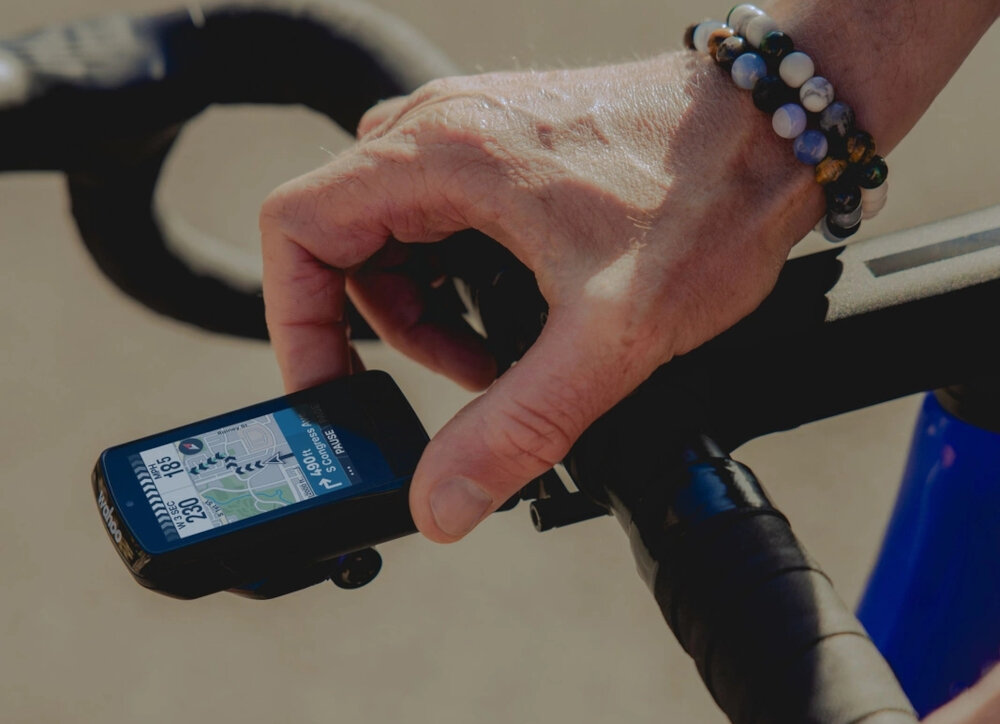 Nawigacja rowerowa WAHOO Elemnt Bolt 3 WFCC9 droga rower nawigacja umieszczona na kierownicy osoba trzyma palce na nawigacji wszechstronne zastosowanie planowanie jazdy jazda na rowerze hobby