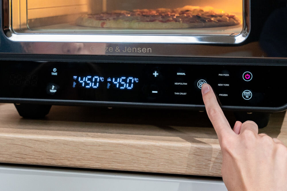 Piec do pizzy GÖTZE & JENSEN PO400K 1700W średnica 32 cm kamień do pieczenia i łopatka w zestawie Czarny zbliżenie na programy na wyświetlaczu 5 gotowych programów tryb do pizzy neapolitańskiej nowojorskiej cienkiego ciasta pieczywa pizzy mrożonej