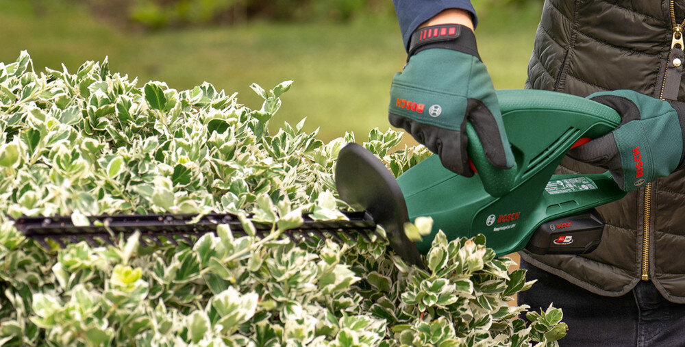 Nożyce do żywopłotu BOSCH EasyHedgeCut 18V-44-11 ogród osoba tnie żywopłot trzymając nożyce w dłoniach lekka i ergonomicznie zaprojektowana konstrukcja miękka powłoka antypoślizgowa komfortowy włącznik ułatwia precyzyjne prowadzenie narzędzia zmniejsza zmęczenie dłoni stabilny chwyt