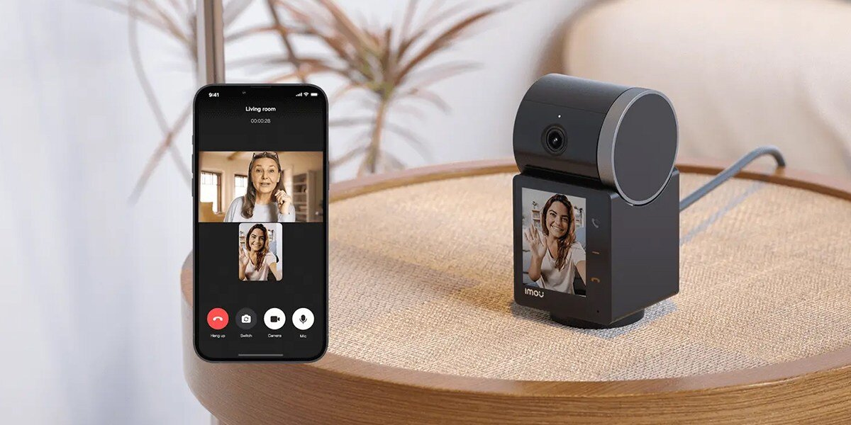 Kamera IMOU Rex VT Pro Wewnętrzna, Wi-Fi, pion, poziom, kąt, obrót, na stoliku w pokoju stoi kamera obok smartfon z aplikacją imou