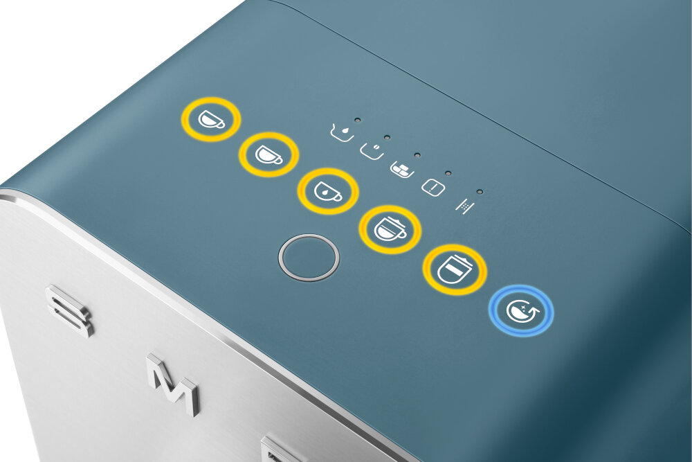 Na obrazie widoczny jest panel sterowania ekspresu do kawy z kilkoma ikonami filiżanek otoczonymi żółtymi okręgami oraz jedną ikoną z niebieskim okręgiem. Na obudowie znajduje się logo \'S M\'.