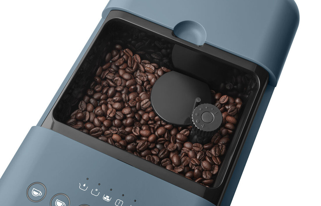Zdjęcie przedstawia górną część ekspresu do kawy z widocznym pojemnikiem na ziarna kawy. Na obudowie znajdują się ikony symbolizujące różne funkcje urządzenia.