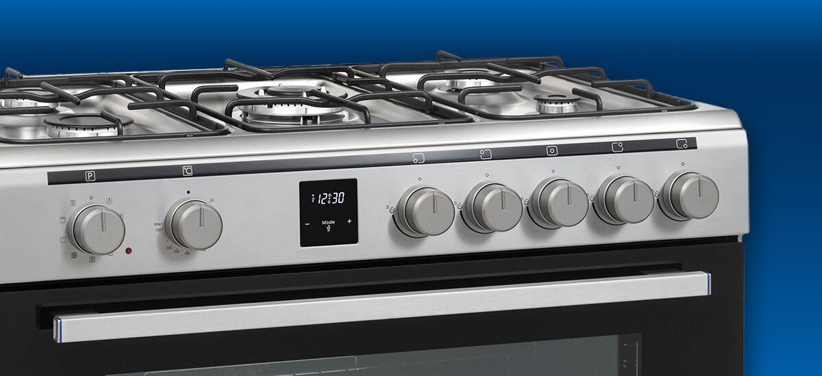 KUCHNIA DAEWOO F96CGDTE19INM-EE Zdjęcie przedstawia górną część kuchni wolnostojącej Daewoo z płytą gazową, czterema palnikami i metalowymi rusztami. Zdjęcie przedstawia także panel frontowy z szeregiem pokręteł do sterowania palnikami i piekarnikiem oraz centralnym wyświetlaczem elektronicznym zabezpieczenie gazu zapłon w pokrętle gaz ziemny lpg kuchnia bezpieczna
