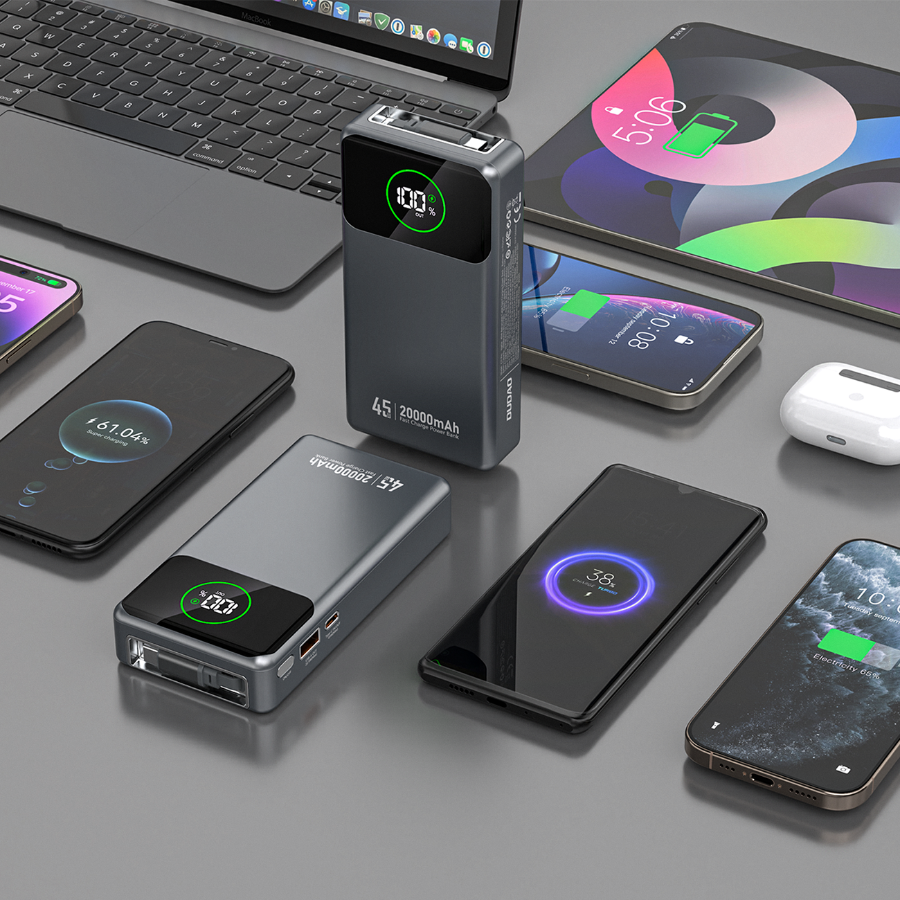Na obrazie widoczny jest szary powerbank z wyświetlaczem pokazującym poziom naładowania, otoczony różnymi urządzeniami elektronicznymi. Na powerbanku znajduje się napis \'45W 20000mAh\'.