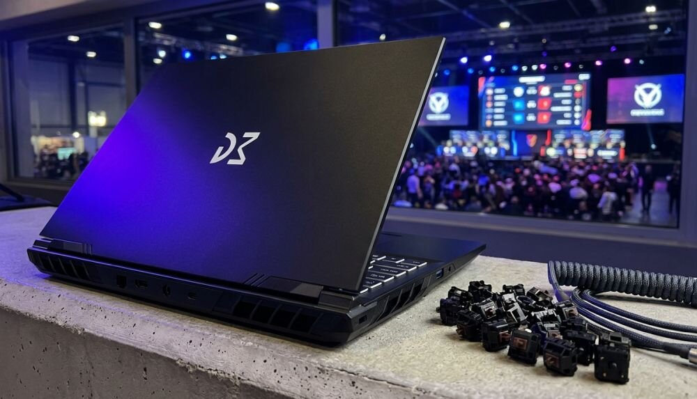Laptop Dream Machines prezentuje obudowę i porty komunikacyjne podczas wydarzenia e-sportowego w hali gamingowej