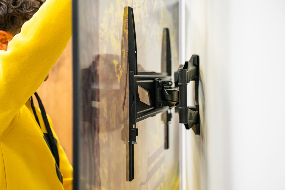 Uchwyt GOLDENLINE TM3770FMS do TV 37-90 cali z widoczną wbudowaną poziomicą przykręcany do ściany wkrętarką