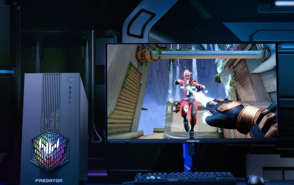 Komputer ACER Predator Orion 3000 PO3-665 Zbliżenie na monitor z uruchomioną grą oraz stojący obok komputer z podświetlonym frontem w kształcie sześciokąta, chłodzenie, wentylatory, podświetlenie
