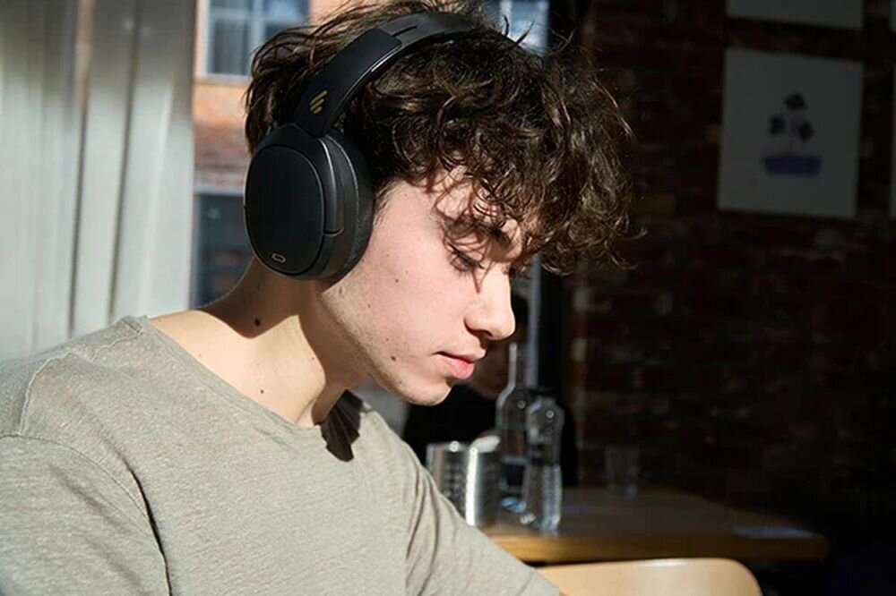 Słuchawki nauszne EDIFIER W80 Bluetooth 5.4 połączenie z dwoma urządzeniami kabel AUX 3,5 mm zasięg 10 m, osoba z założonymi słuchawkami nausznymi