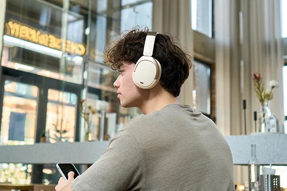 Słuchawki nauszne EDIFIER W80 tryb Music Spatial Sound Game 0,08 s aplikacja EDIFIER ConneX equalizer ANC, osoba z założonymi słuchawkami nausznymi