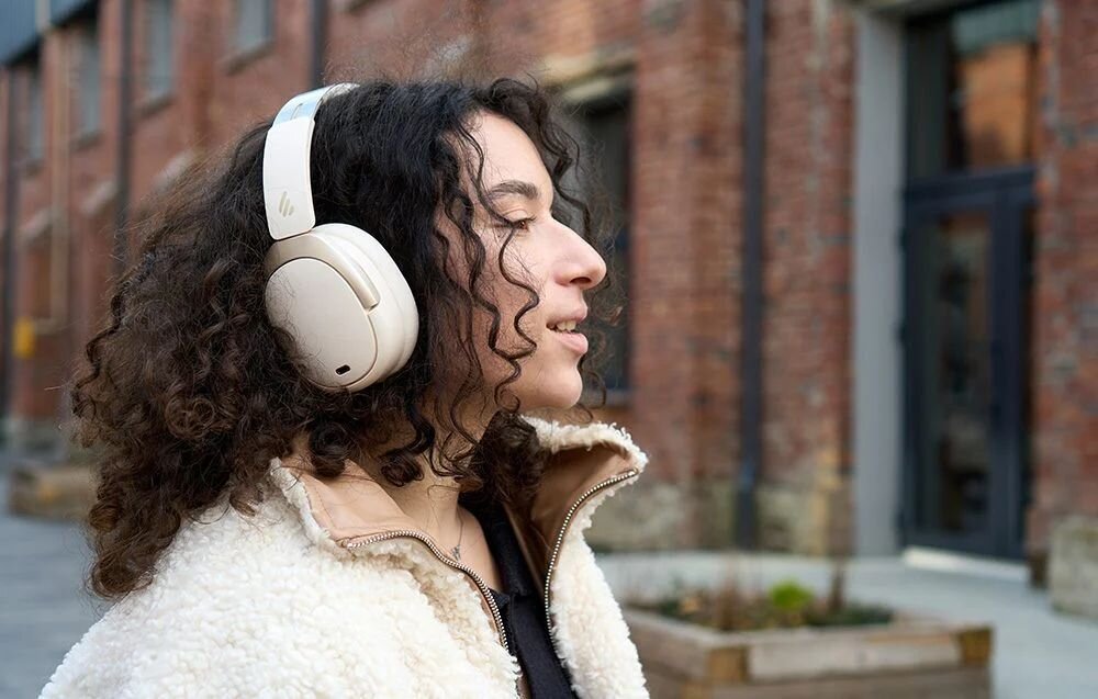 Słuchawki nauszne EDIFIER W80 przyciski sterowania regulacja głośności zmiana utworów asystent głosowy przełączanie ANC, osoba z założonymi słuchawkami nausznymi