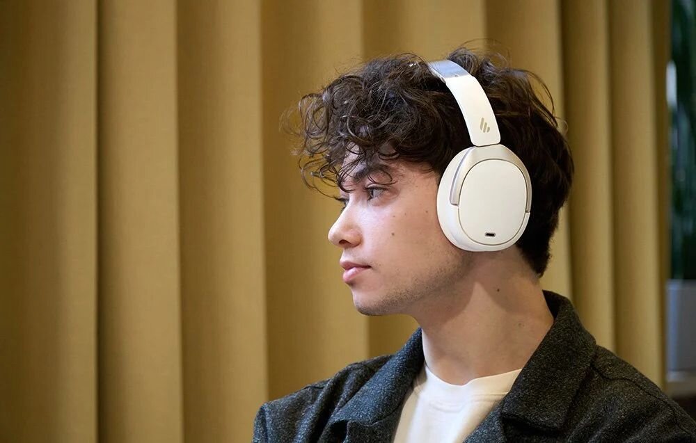 Słuchawki nauszne EDIFIER W80 bezprzewodowe ANC Hi-Res Audio 65 godzin pracy redukcja hałasu do 49 dB Bluetooth 5.4, osoba z założonymi słuchawkami nausznymi