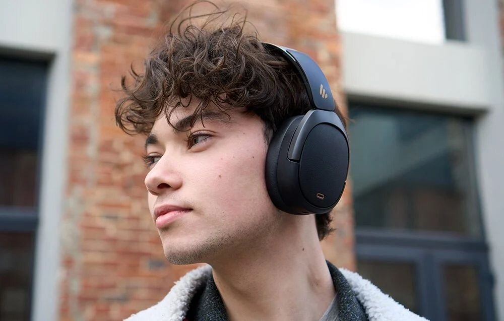 Słuchawki nauszne EDIFIER W80 przyciski sterowania regulacja głośności zmiana utworów asystent głosowy przełączanie ANC, osoba z założonymi słuchawkami nausznymi