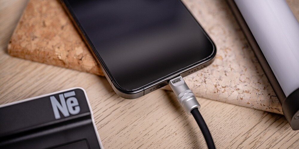Telefon podłączony  silikonowym kablem Newell USB-C - USB-C 100 W, 2 m do ładowarki marki Newell.