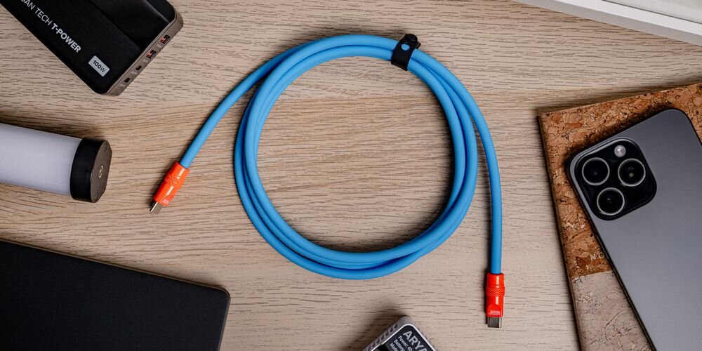 Kabel Newell USB-C - USB-C 100 W, 2 m, silikonowy, na drewnianym blacie pośród sprzętów, które można nim naładować