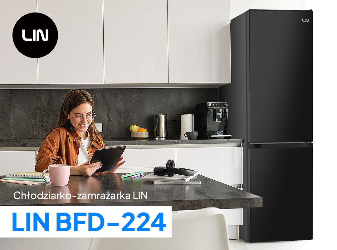 Lodówka LIN LI-BFD224 Na zdjęciu znajduje się kuchnia z jasnymi meblami, gdzie przy stole siedzi kobieta z tabletem i kubkiem. W tle widoczna jest lodówko-zamrażarka marki LIN oraz ekspres do kawy, czajnik i misa z owocami. U dołu zdjęcia znajduje się napis Chłodziarko-zamrażarka LIN LIN BFD-224.